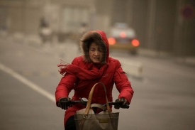 Číňanka v písečné bouři v centru Pekingu.